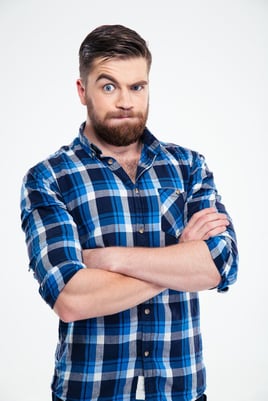 Portrait of amazed casual man standing with arms folded isolated on a white background