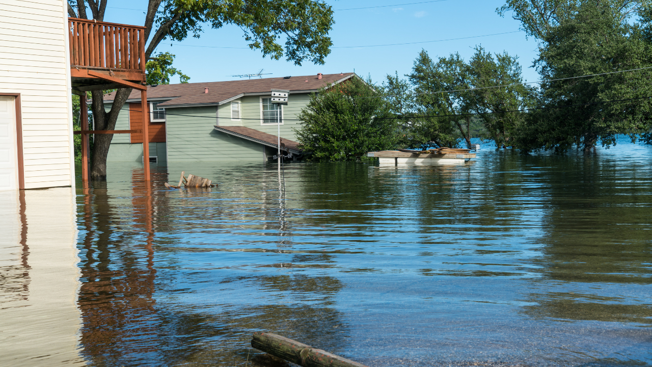 Flooded residential neighborhood with homes partially underwater and high water levels surrounding houses