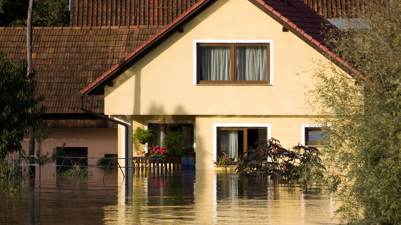 Floodwater surrounding a residential home illustrating the importance of flood insurance for homeowners