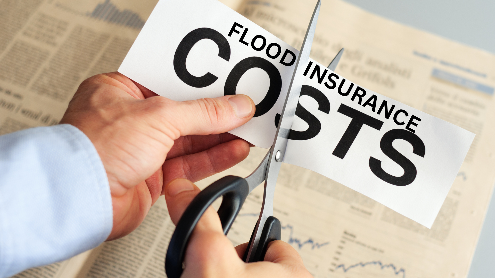 Close-up of hands cutting a paper labeled 'Flood Insurance Costs' with scissors, symbolizing savings on insurance premiums