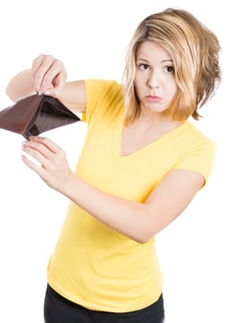 A close-up picture of a cute young surprised, unhappy, puzzled woman, girl holding an empty wallet, isolated  on a white background