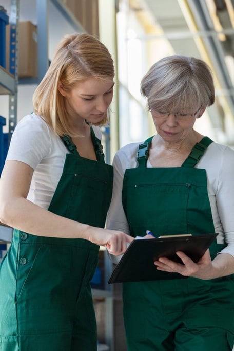 Two women and team work in big storehouse