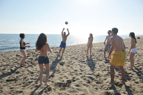 young people group have fun and play beach volleyball at sunny summer day