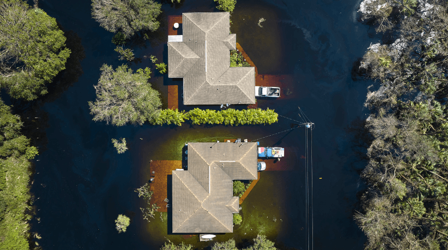 aerial top view of two properties surrounded by trees and flood