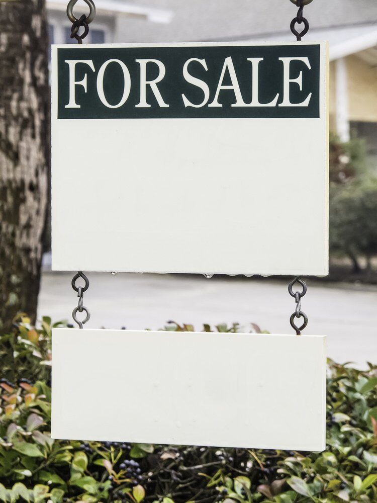 Real estate sign with drops of water hanging in front yard, with white copy space for your message and sub-message (shallow depth of field)